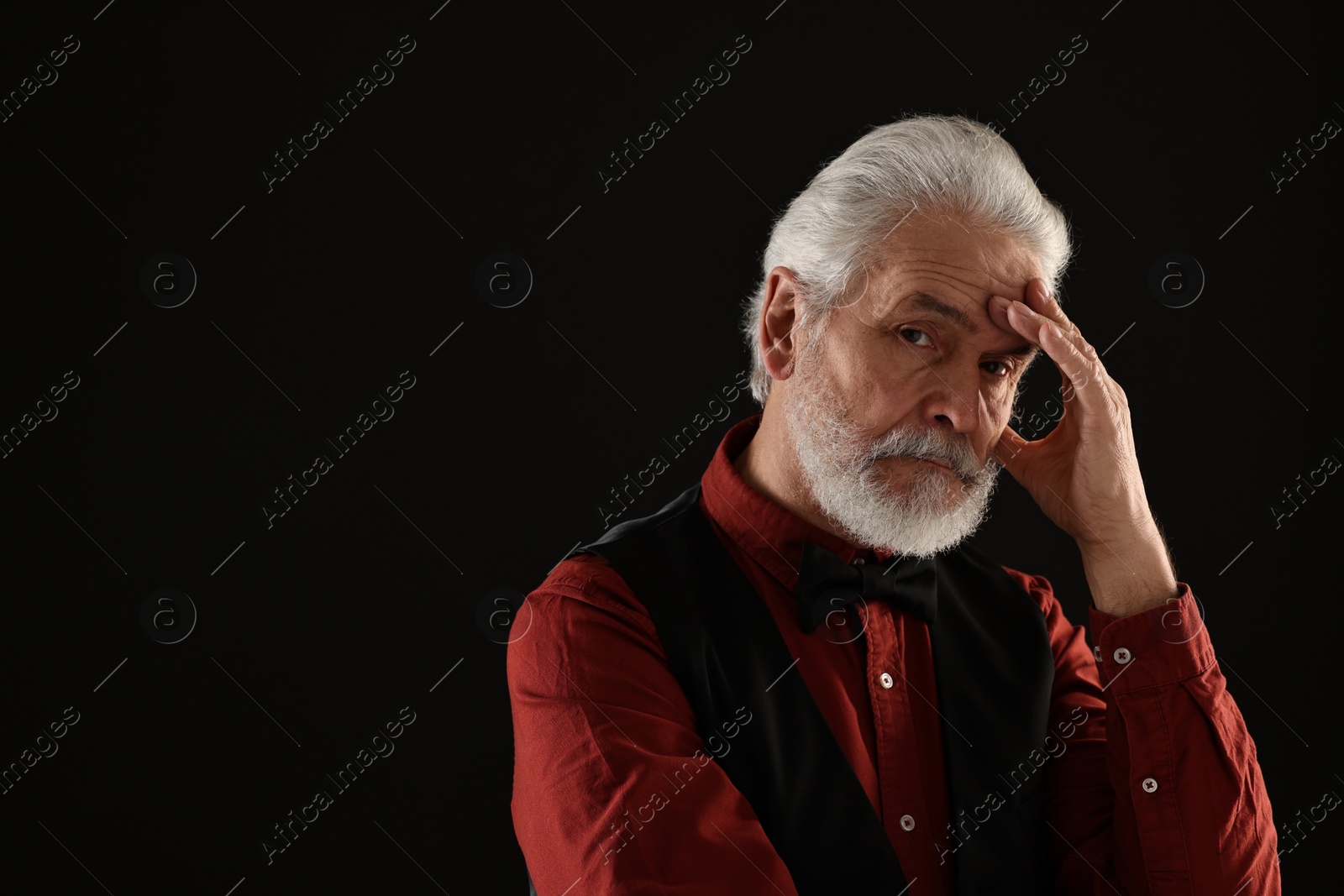 Photo of Senior man touching mustache on black background, space for text