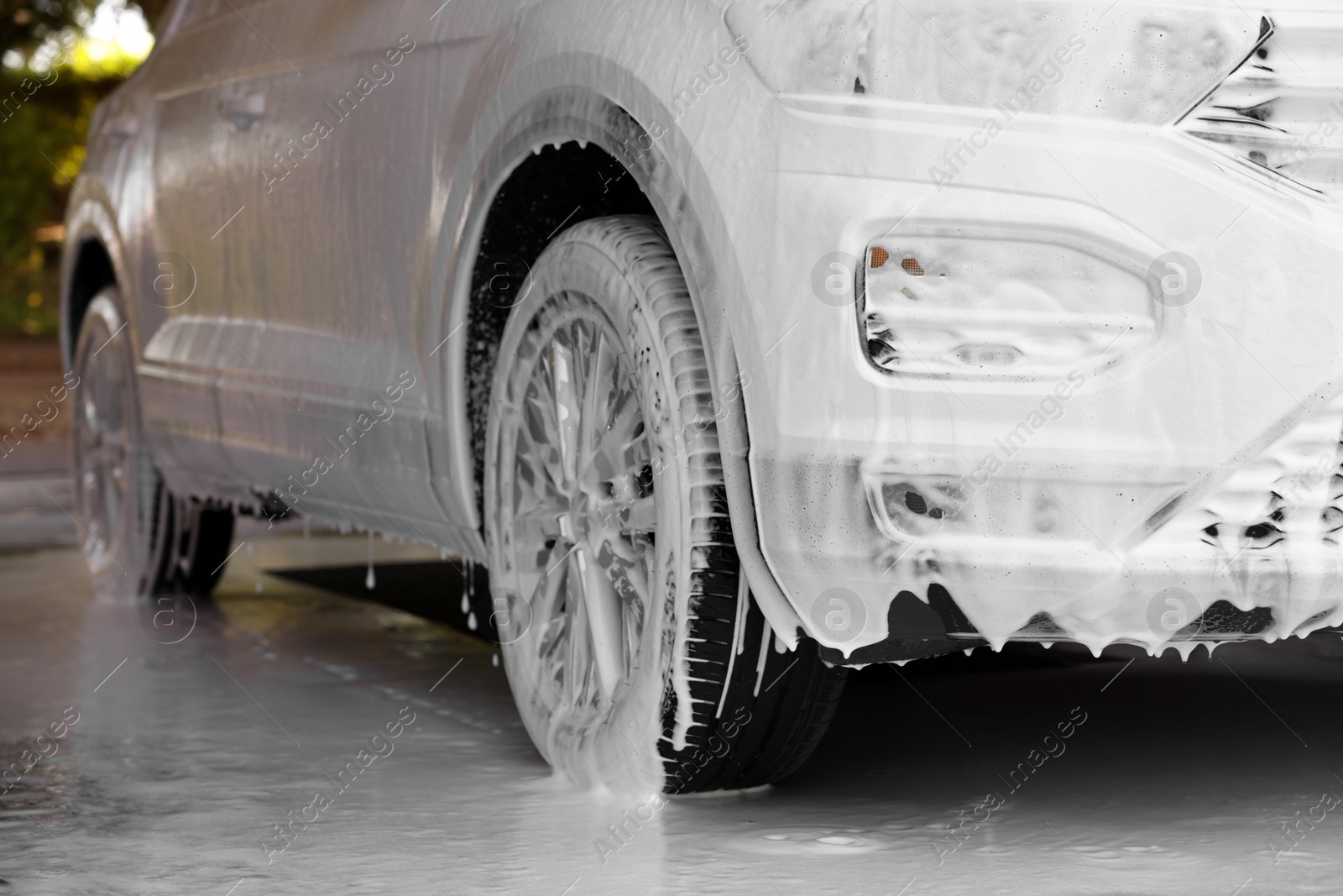 Photo of Auto covered with cleaning foam at outdoor car wash