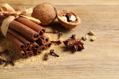 Different spices and nuts on wooden table, closeup