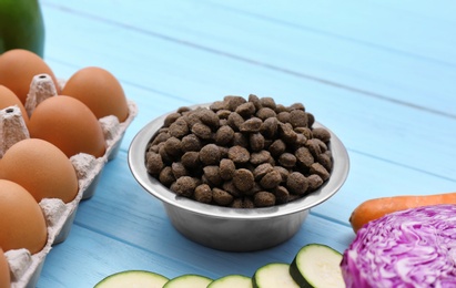 Photo of Composition with dry and natural dog food on wooden background