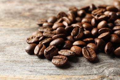 Photo of Roasted coffee beans on wooden background, closeup