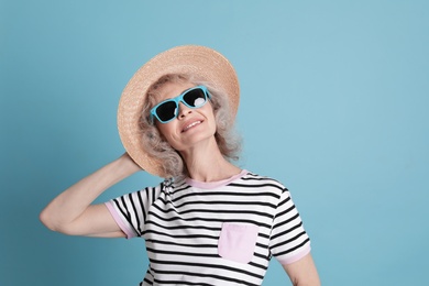 Portrait of mature woman in hipster outfit on color background