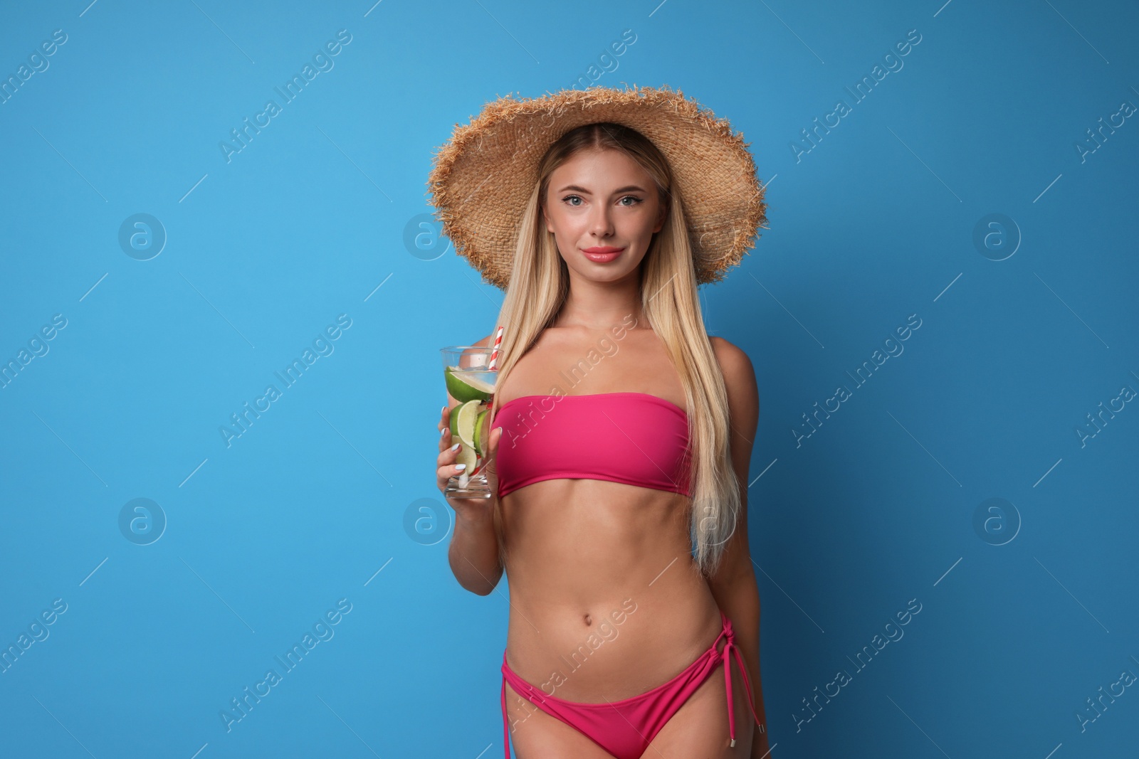 Photo of Pretty young woman wearing stylish bikini with cocktail on blue background