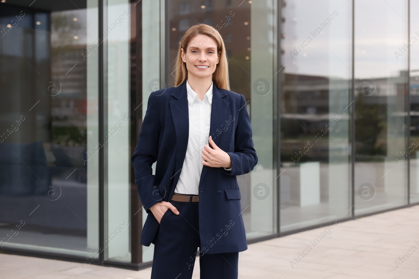 Photo of Happy real estate agent in suit outdoors