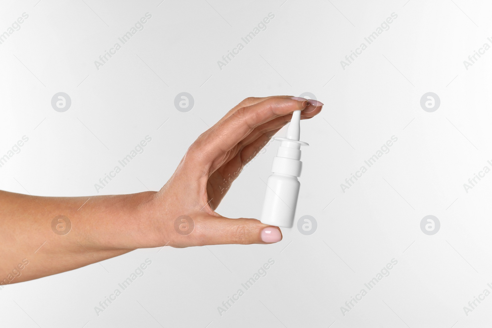 Photo of Woman holding nasal spray on white background, closeup