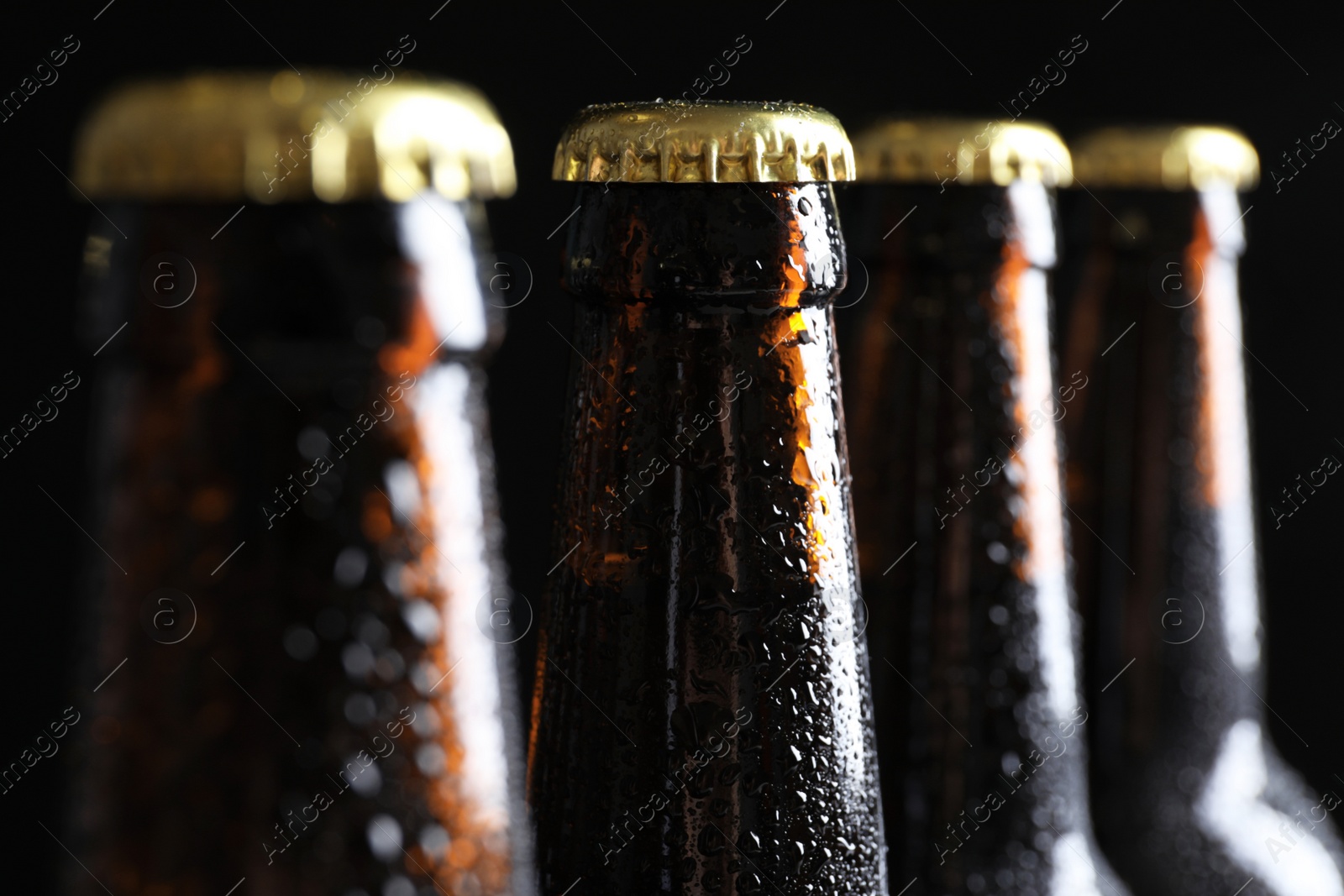 Photo of Many bottles of beer on dark background, closeup view