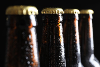 Photo of Many bottles of beer on dark background, closeup view