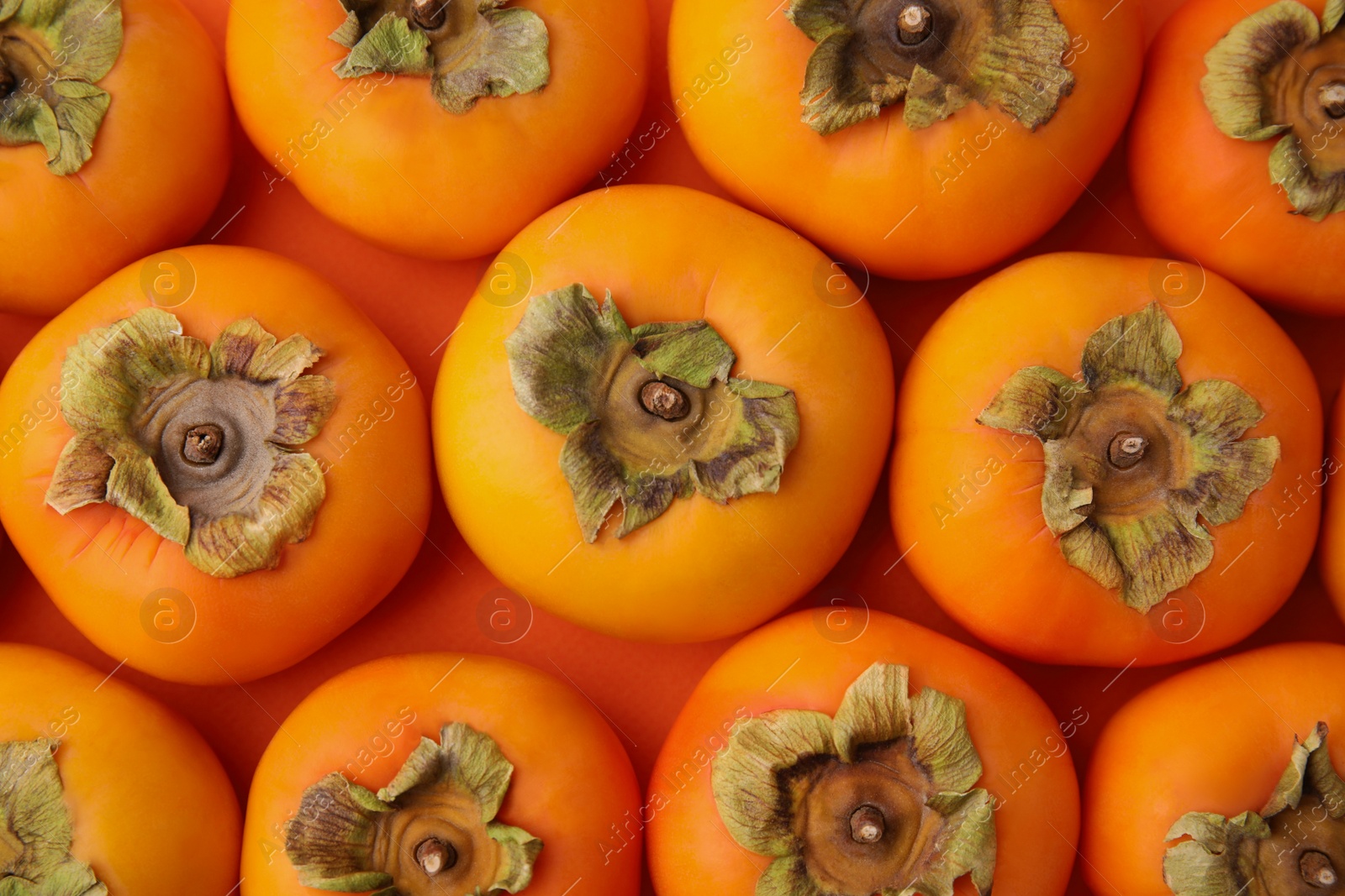 Photo of Delicious ripe juicy persimmons as background, top view