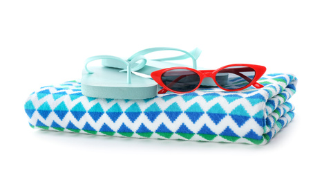 Photo of Bright towel, sunglasses and flip flops on white background. Beach objects