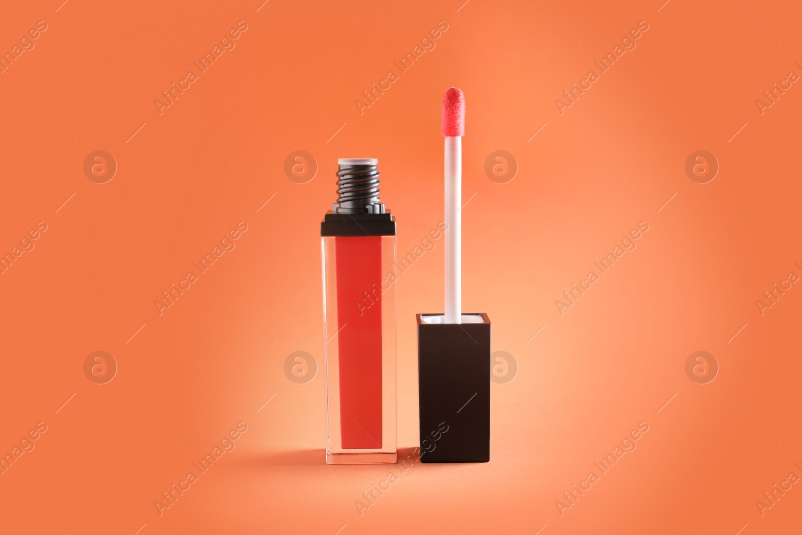 Photo of Liquid lipstick tube with applicator on color background