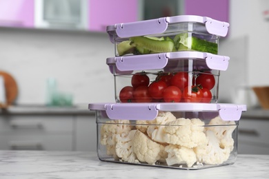 Boxes with fresh raw vegetables on table in kitchen, space for text