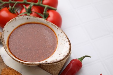 Photo of Fresh marinade and ingredients on white tiled table, closeup. Space for text
