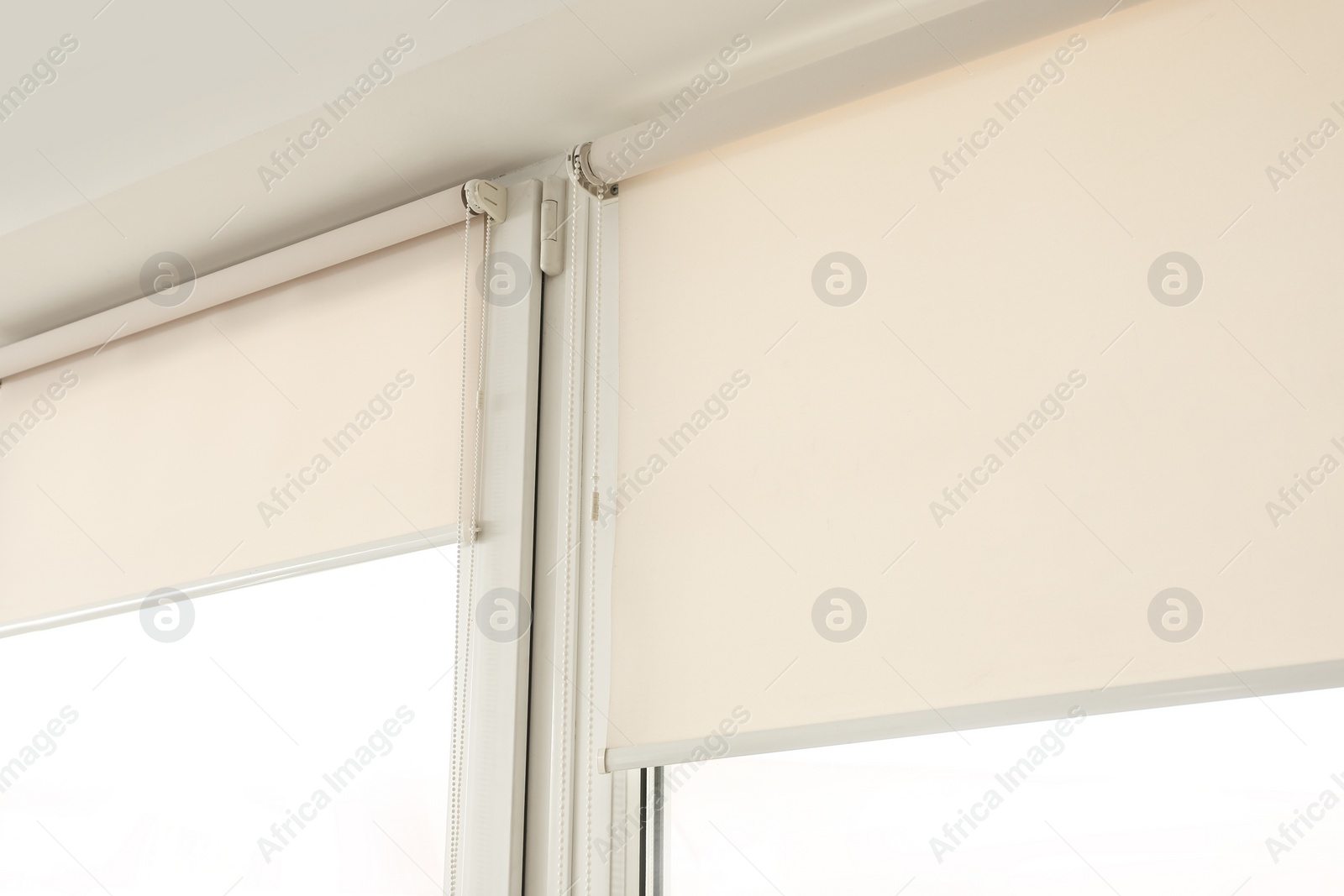 Photo of Window with modern roll blinds in room, closeup