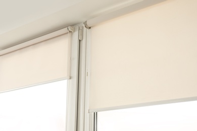 Window with modern roll blinds in room, closeup