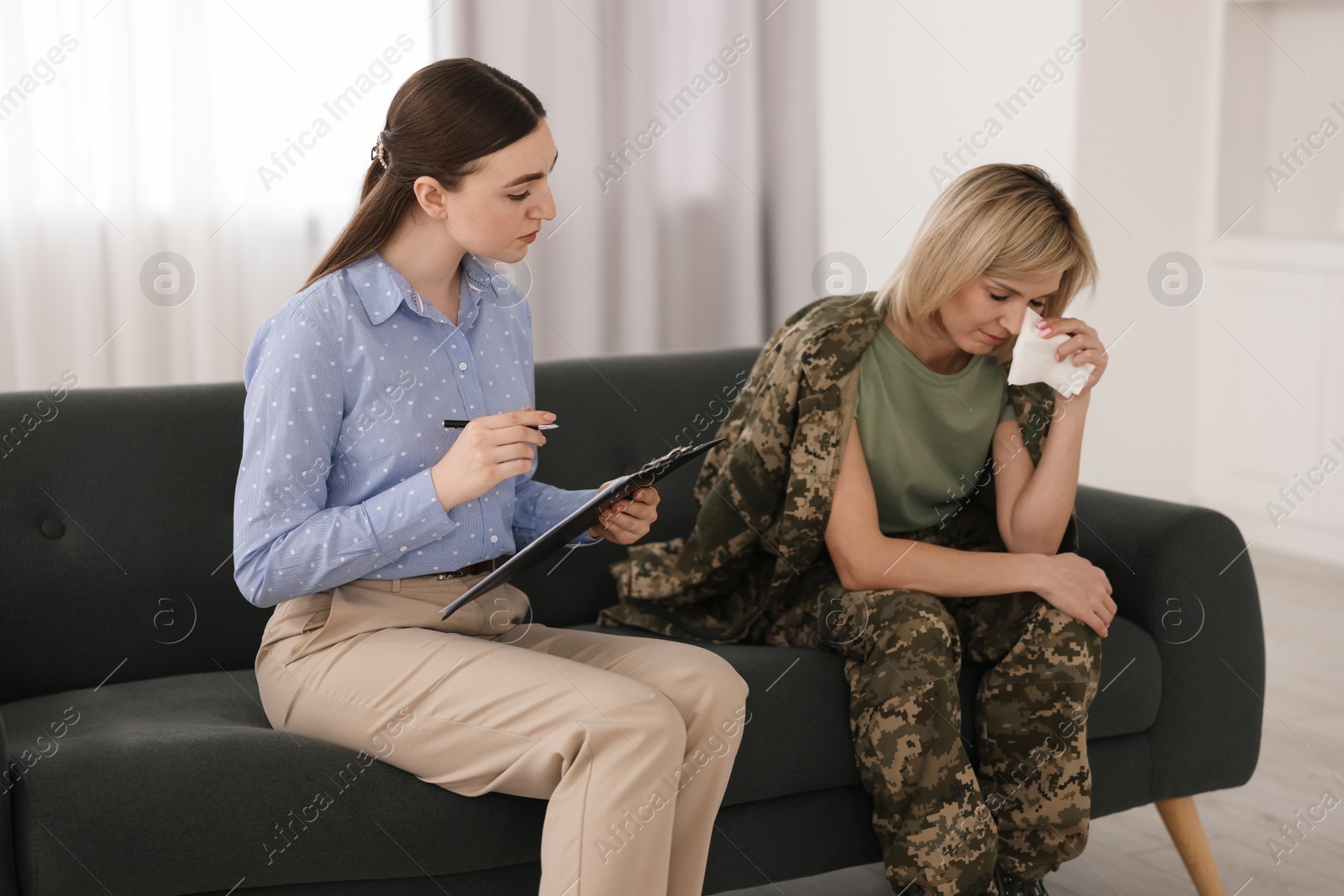 Photo of Psychotherapist working with military woman on sofa in office