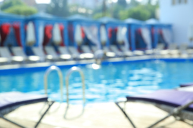 Blurred view of modern outdoor swimming pool on sunny day