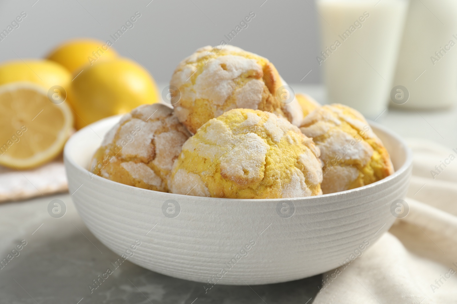 Photo of Delicious lemon cookies in bowl on grey table, closeup