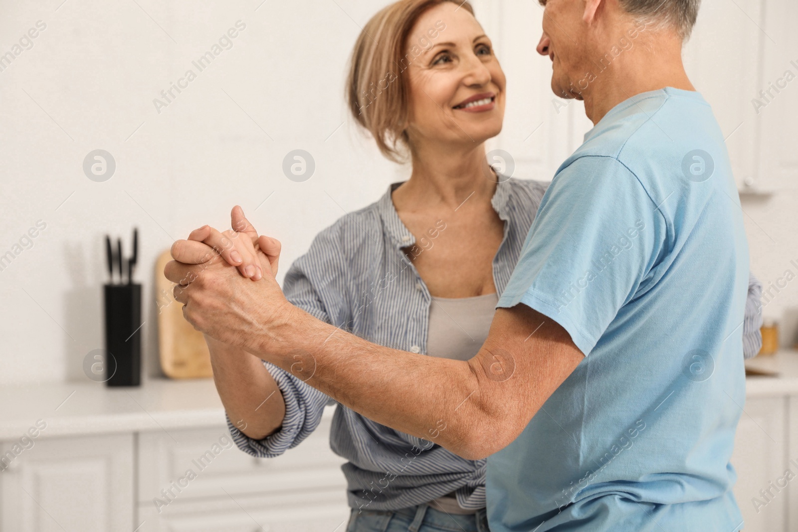 Photo of Happy senior couple dancing in kitchen, closeup