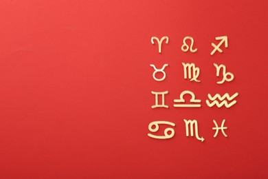 Photo of Zodiac signs on red background, flat lay. Space for text
