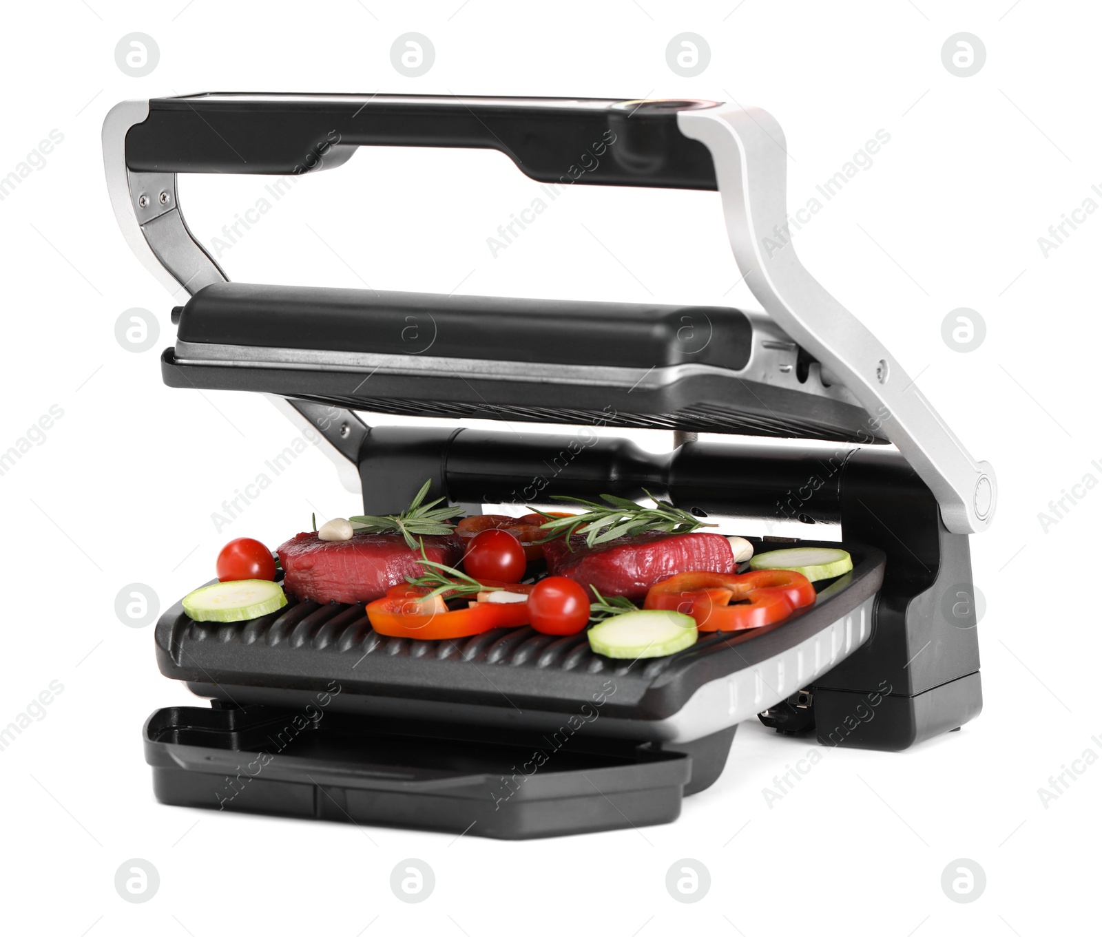 Photo of Electric grill with raw meat, rosemary and vegetables isolated on white