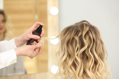 Photo of Hair styling. Professional hairdresser working with client indoors, closeup