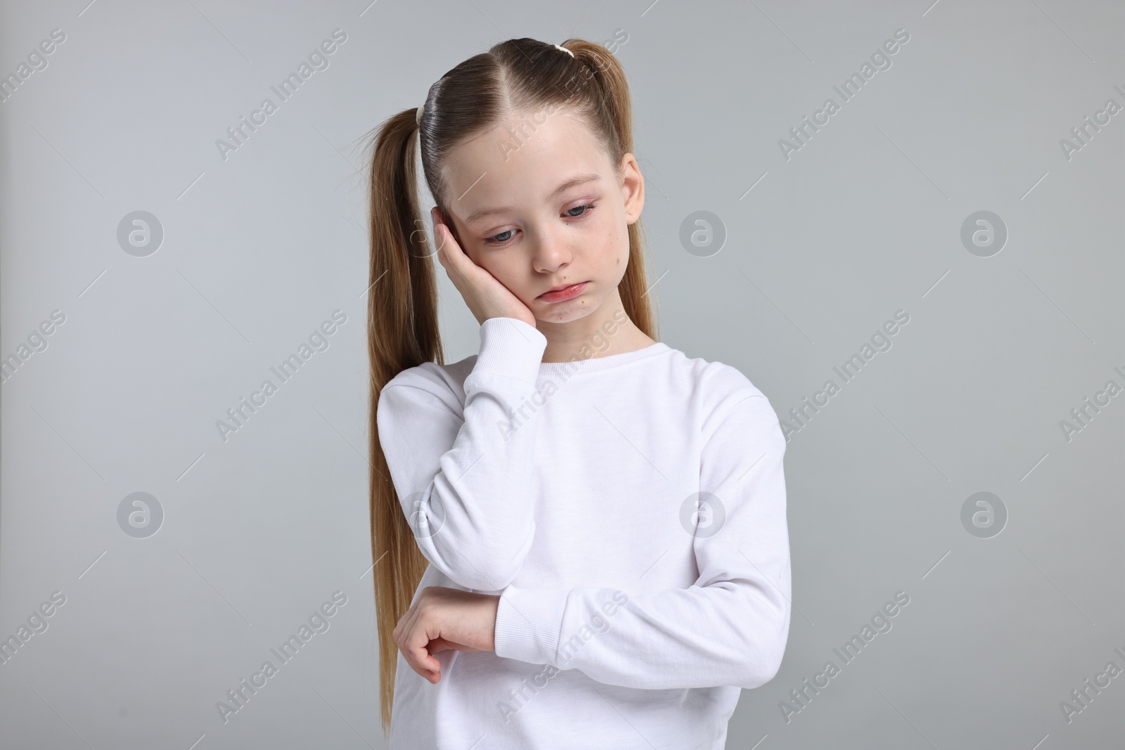 Photo of Portrait of sad girl on light grey background