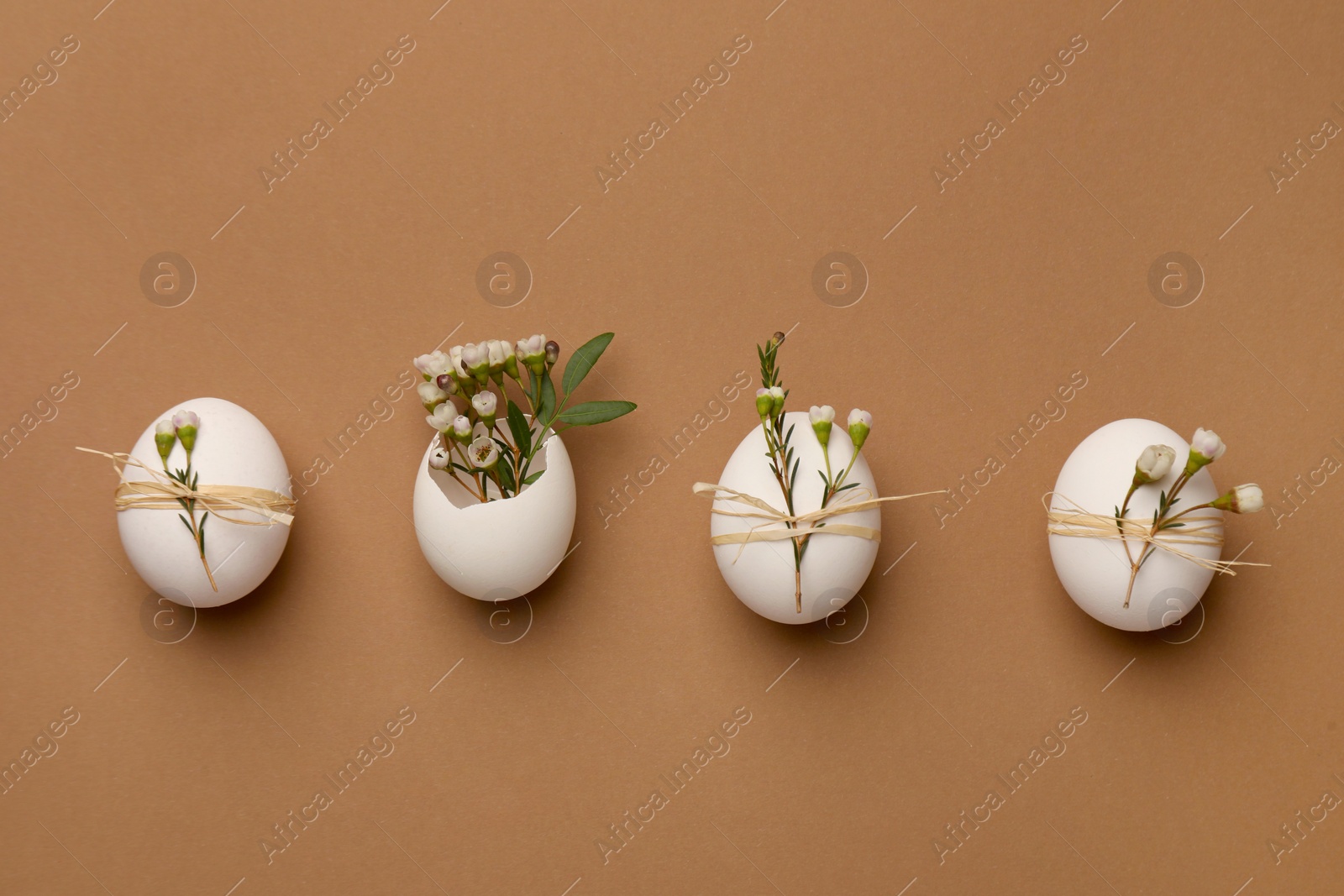 Photo of Festively decorated chicken eggs on brown background, flat lay. Happy Easter