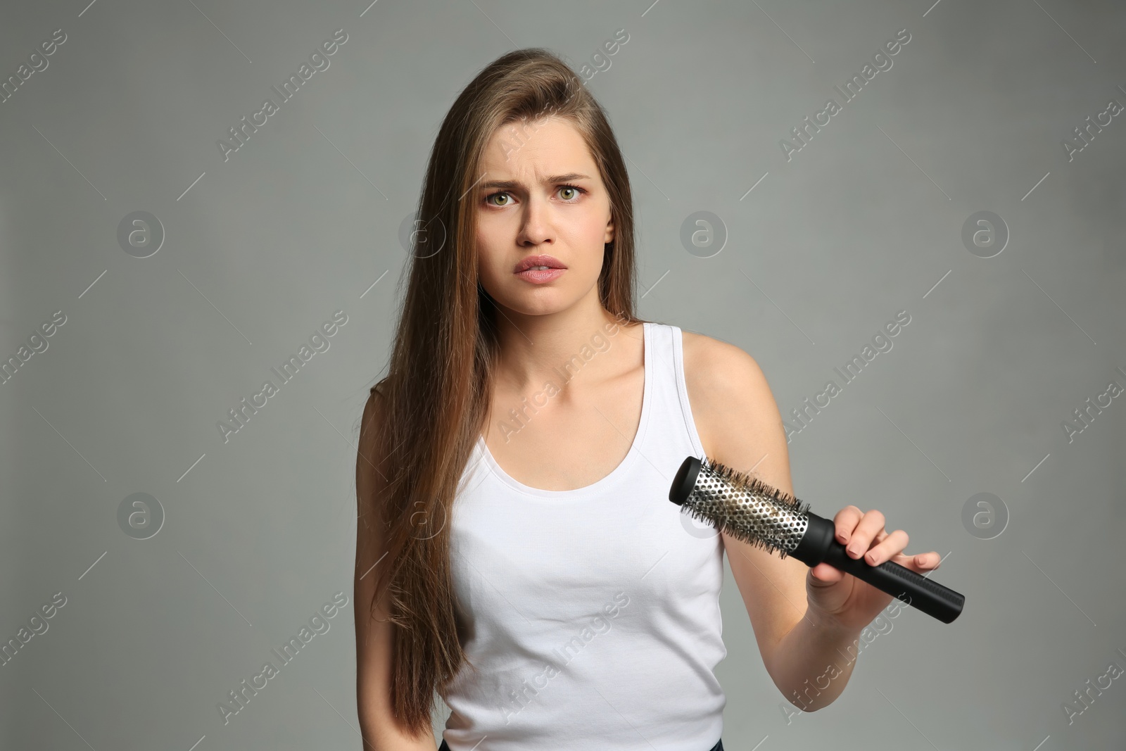 Photo of Young woman with hair loss problem on light background