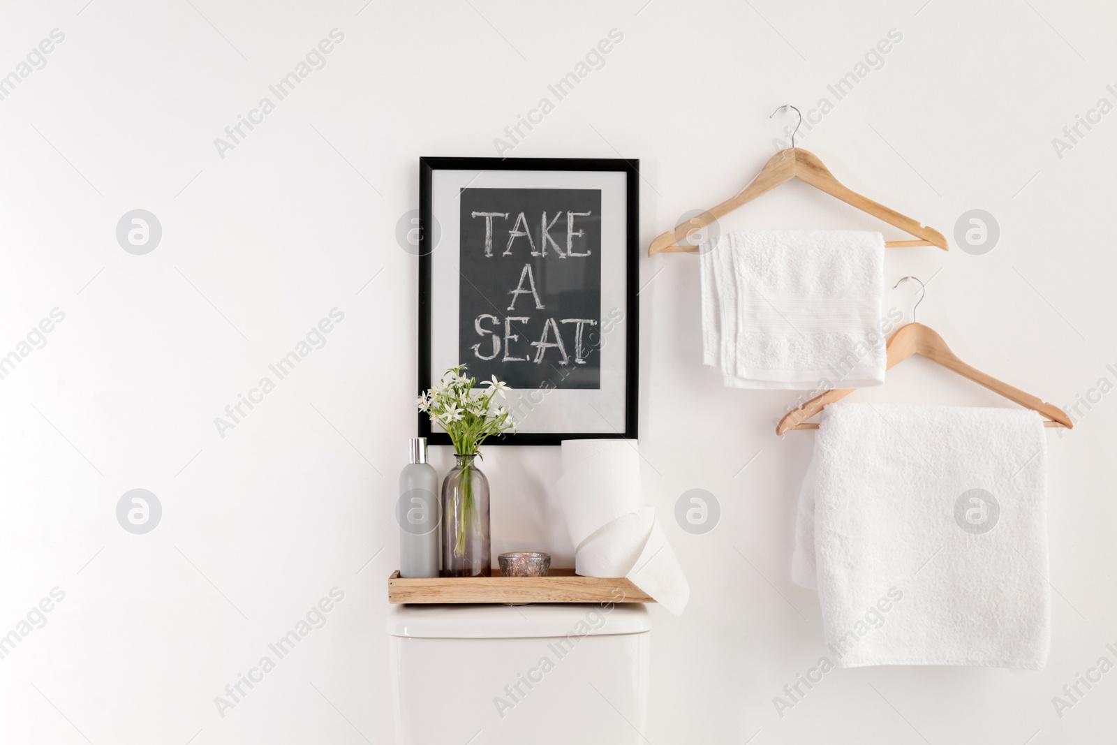 Photo of Decor elements, necessities and toilet bowl near white wall, space for text. Bathroom interior