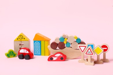 Different wooden toys on light pink background. Children's development