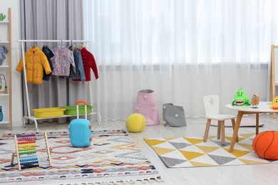 Photo of Child`s playroom with different toys and modern furniture. Stylish kindergarten interior