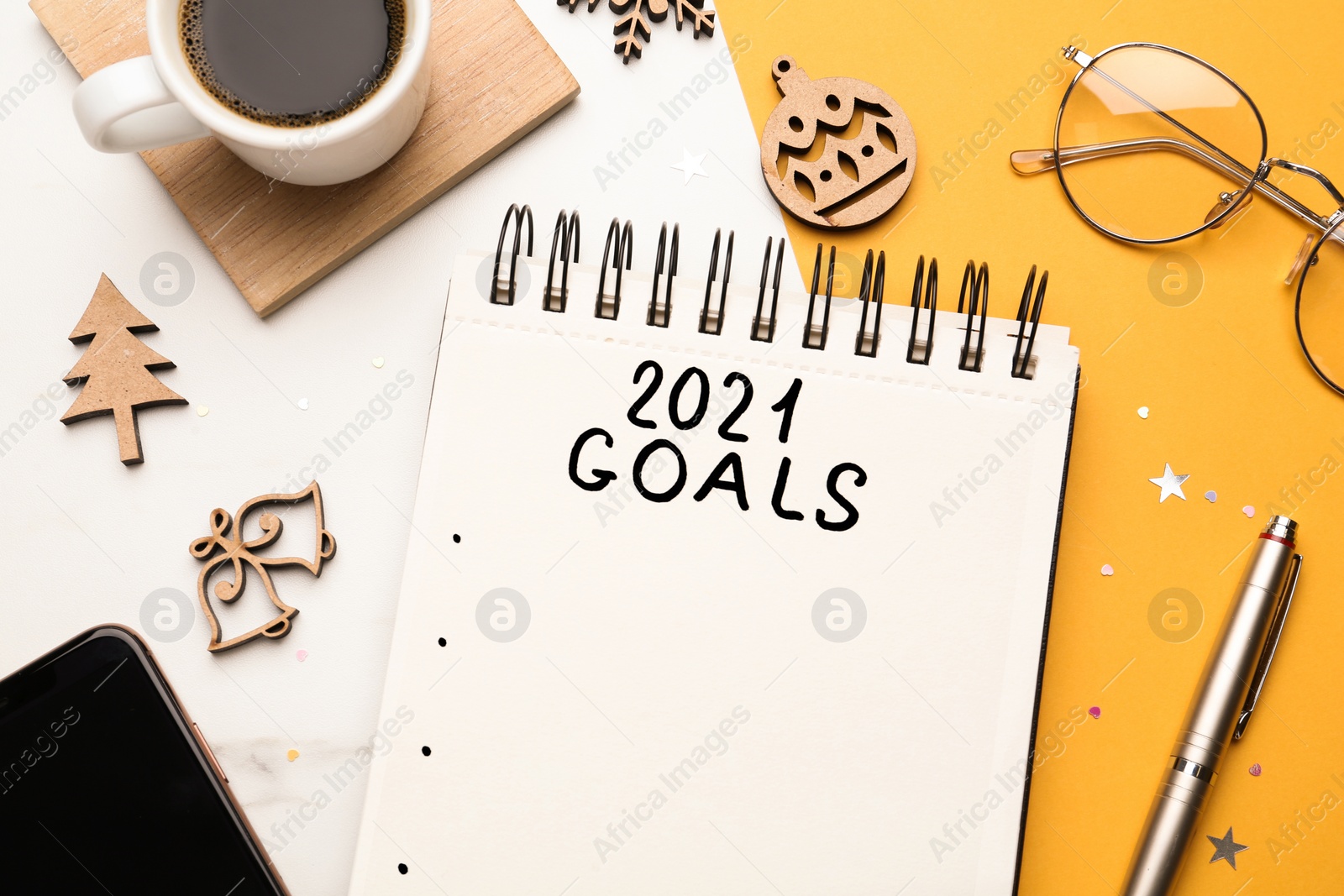 Photo of Flat lay composition with notebook and festive decor on color background. Goals for New Year 2021