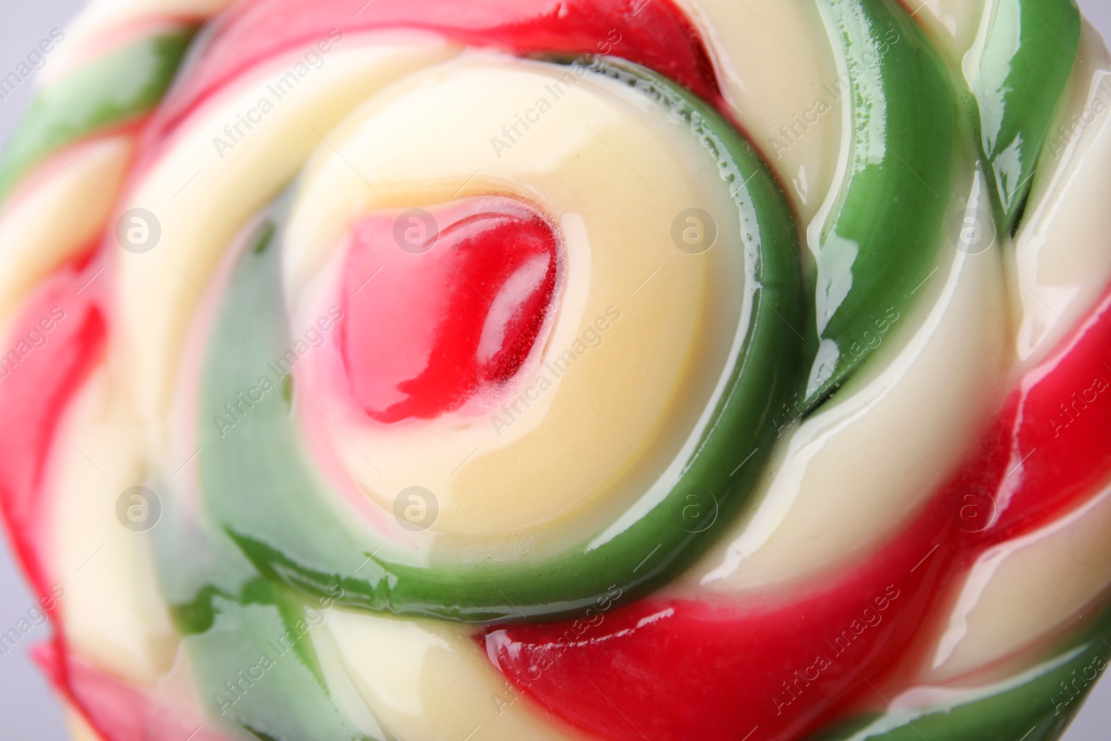 Photo of Colorful lollipop swirl on grey background, closeup