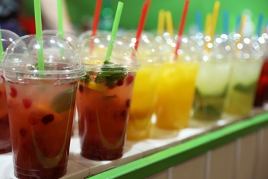 Photo of Plastic cups with refreshing drinks on bar counter