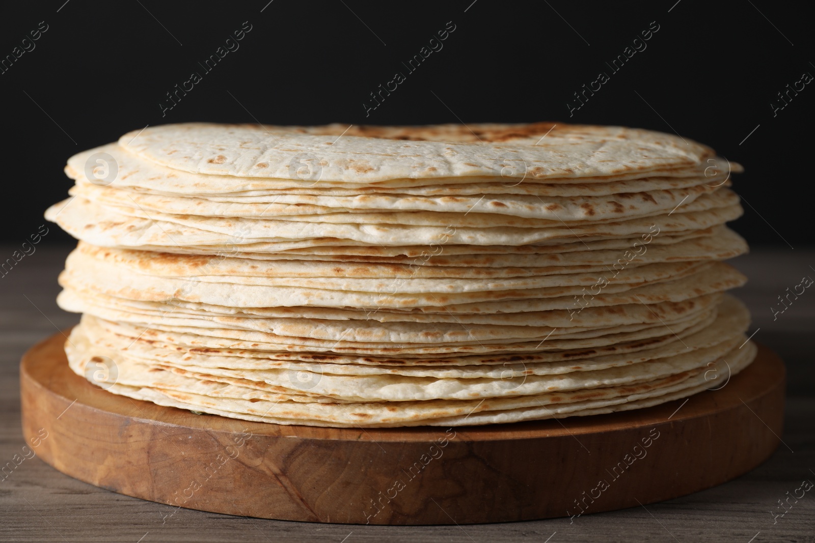 Photo of Many tasty homemade tortillas on wooden table