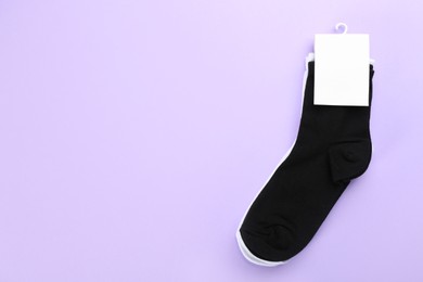 Photo of Soft cotton socks on lilac background, top view. Space for text