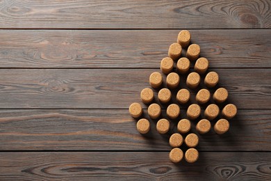 Photo of Christmas tree made of wine corks on wooden table, top view. Space for text