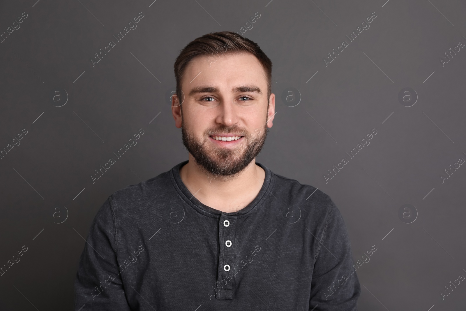 Photo of Portrait of happy young man on grey background. Personality concept