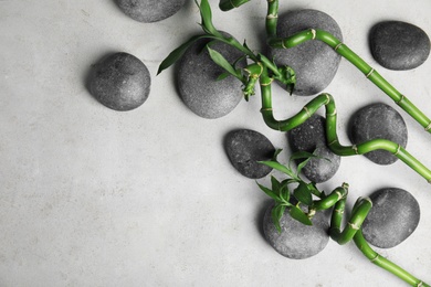 Photo of Zen stones and bamboo on grey background, top view with space for text