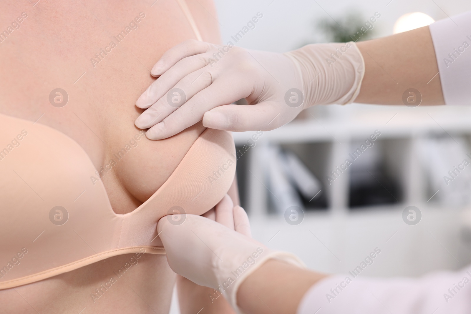 Photo of Mammologist checking woman's breast in hospital, closeup