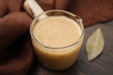 Photo of Delicious turkey gravy on wooden table, closeup