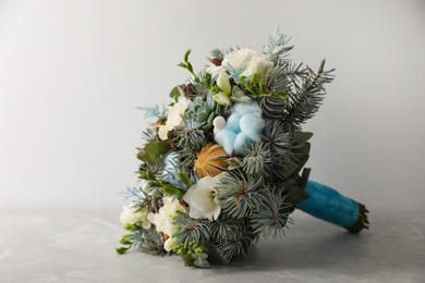 Photo of Beautiful wedding winter bouquet on grey table. Space for text
