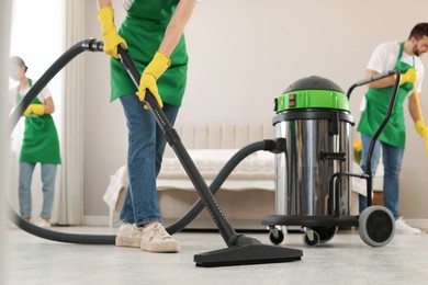 Photo of Team of professional janitors working in bedroom, closeup