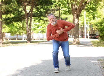 Photo of Mature man having heart attack in park