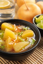 Photo of Bowl of tasty turnip soup served on table, closeup