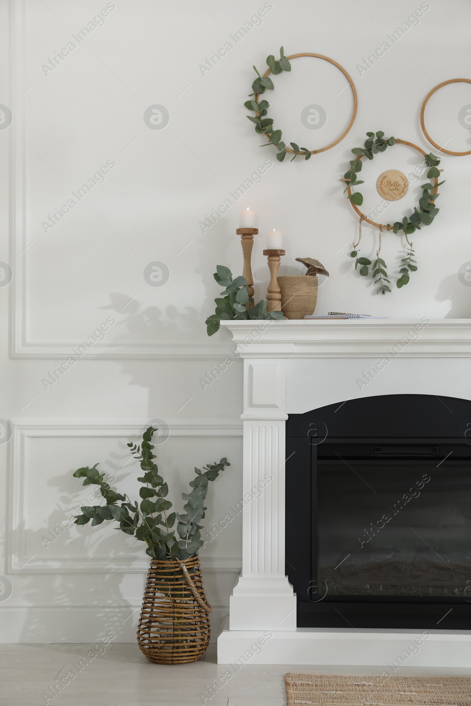 Photo of Stylish room with beautiful fireplace and eucalyptus branches