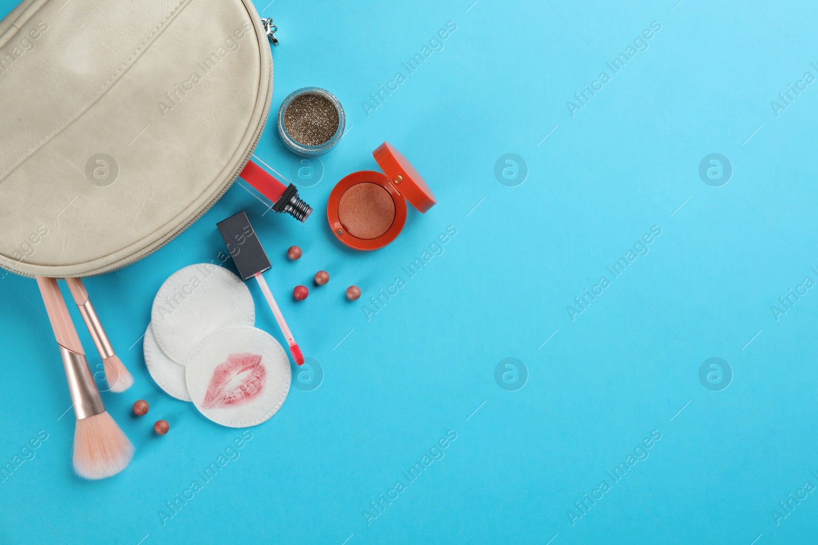 Photo of Clean and dirty cotton pads, cosmetic with brushes in bag on turquoise background, flat lay. Space for text