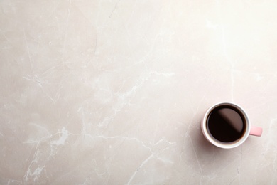 Photo of Ceramic cup with hot aromatic coffee on marble background, top view