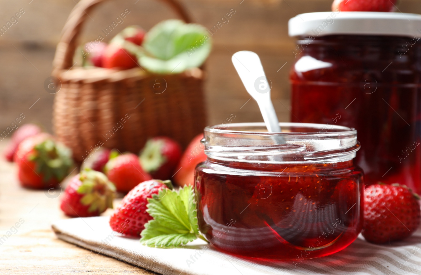 Photo of Delicious pickled strawberry jam and fresh berries on wooden table