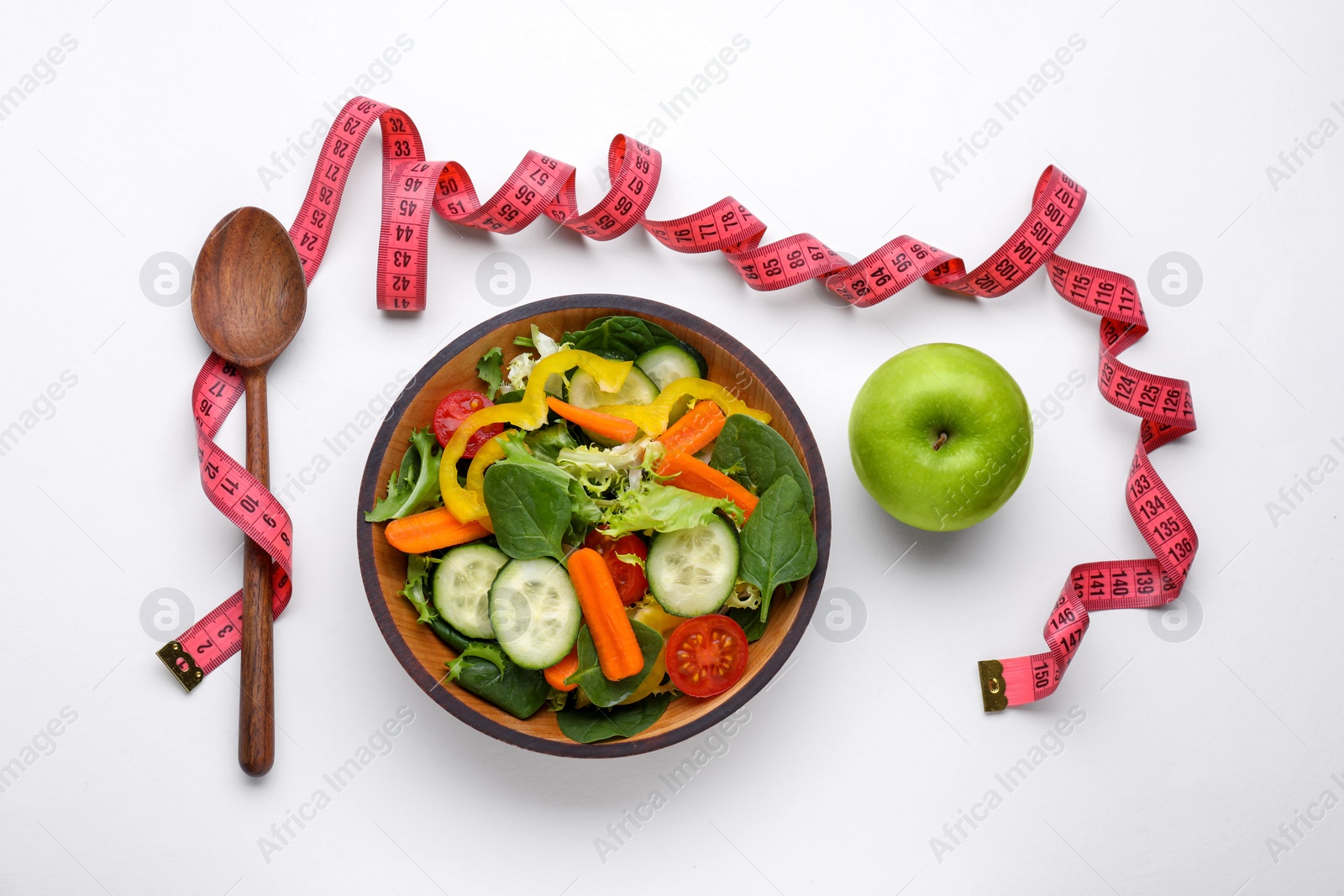 Photo of Measuring tape, salad, apple and spoon on white background, flat lay